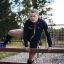 Un homme utilisant l’équipement d’aire de jeux extérieure Double Jump Bars.
