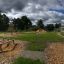 Parc de fitness extérieur avec équipement d’exercice en bois dans un espace vert ouvert.