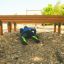 Personne rampant sous un parcours d'obstacles en bois Hip Hop sur une aire de jeux.