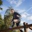 Homme grimpant sur Climb Obstacle wooden ladder dans un parc extérieur.