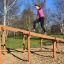 Femme grimpant sur Climb Obstacle wooden ladder dans un parc.