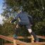 Homme grimpant sur Climb Obstacle wooden ladder dans un parc extérieur.