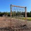 V-shape Net Large climbing net dans une aire de jeux extérieure avec sol en copeaux de bois.