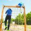 Enfants grimpant sur un V-shape Net Large climbing net dans un parc.