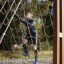 Homme grimpant sur V-shape Net Large climbing net dans une aire de jeux extérieure.
