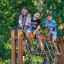 V-shape Net Large climbing net dans une aire de jeux avec trois enfants qui grimpent et s'y assoient