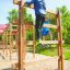 Des enfants grimpent sur Step And Climb wooden ladder dans une aire de jeux.