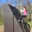 Femme grimpant sur le Climbing Ramp steel structure dans une aire de jeux extérieure.