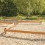 Poutres d’équilibre en bois dans une aire de jeux extérieure.