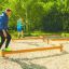 Adultes et enfants en équilibre sur l’équipement de fitness extérieur Balance.