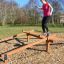 Femme en équilibre sur l’équipement de terrain de jeu extérieur Easy Balancer.