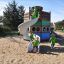Des enfants jouent sur Majestic ship with slide dans une aire de jeux sablonneuse.