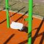 Balançoire simple avec cadre en métal vert et siège blanc sur une surface de terrain de jeu orange.