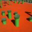 Vert Jumping pegs (5 pcs.) sur une aire de jeux orange.