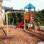 Double Swing with Tower playhouse with slide dans une aire de jeux de jardin