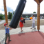 Enfant jouant avec un Punching bag sur une aire de jeux.