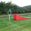 Ramp : rampe de jeu extérieure rouge dans une zone de parc herbeuse.