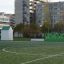 Maison de jeu Shelter sur un terrain de sport avec des immeubles de la ville en arrière-plan.