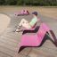 Homme assis sur un Lounge chair rose d'extérieur par une journée ensoleillée.