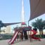 Équipement de aire de jeux Twister castle with slide dans un parc urbain avec le Burj Khalifa en arrière-plan