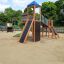 Twister castle with slide sur une aire de jeux sablonneuse