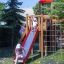 Enfants jouant sur Twister castle with slide dans un parc.