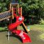 Enfants jouant sur Twister castle with slide dans un parc.