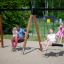 Double Swing (BNS 90cm) utilisé dans une aire de jeux avec des familles profitant des balançoires.