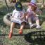 Deux enfants assis sur un Double Swing (BNS 90cm) lisant un livre.