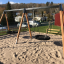 Double Swing (BNS 90cm) sur une aire de jeux sablonneuse.
