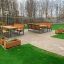 Ensemble extérieur Kyoto Table et bancs installés sur un patio avec de l'herbe verte.