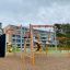 Équipement de terrain de jeu Sirius steel structure avec barres orange et grises dans une cour d'école.