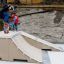 Enfant réalisant une figure en skateboard sur Jump-Ramp, avec un autre enfant qui regarde.