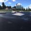 Skatepark avec rampes et obstacles sur une surface asphaltée, mettant en avant le produit Corner.