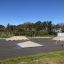 Skatepark extérieur avec rampes et bancs, mettant en avant le produit Corner.