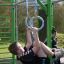 Garçon jouant sur les anneaux de gymnastique de l’équipement de fitness extérieur New Age Fit.
