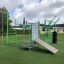 Équipement de fitness extérieur New Age Fit comprenant diverses stations d’entraînement sur un terrain herbeux.