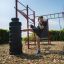 Homme pratiquant des coups de pied sur l’équipement de fitness extérieur New Age Fit.