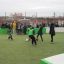 Des enfants jouant au football dans Multiarena avec des spectateurs en arrière-plan.