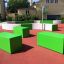 Bancs verts et structures de jeu de Multiarena dans une aire de jeux.