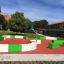 Terrain de sport extérieur moderne Multiarena avec des paniers de basket et des zones d’assise sur un terrain de loisirs.