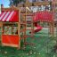 Structure de terrain de jeu en bois avec toboggan rouge et échelle d'escalade.