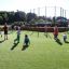 Des enfants jouant sur le terrain de sport Multiarena par une journée ensoleillée.