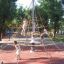 Des enfants jouent sur une structure d’escalade en corde sur Rubber Tiles 75 dans un parc avec des arbres à l’arrière-plan