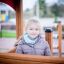 Petite fille jouant à l'intérieur d'un Villa Maxi sandbox with a playhouse.