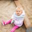 Un tout-petit assis dans le Villa Maxi sandbox with a playhouse.