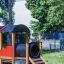 Structure de jeu Train en bois et en plastique avec un toboggan et un tunnel.