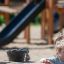 Un enfant jouant avec l’équipement Sand & Water Play Nature sur le terrain de jeu.
