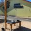 Table d’activités extérieure Sand & Water Play Nature pour enfants devant un bâtiment scolaire.