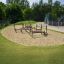 Aire de jeux pour enfants avec structures d'escalade en bois dans un bac à sable.